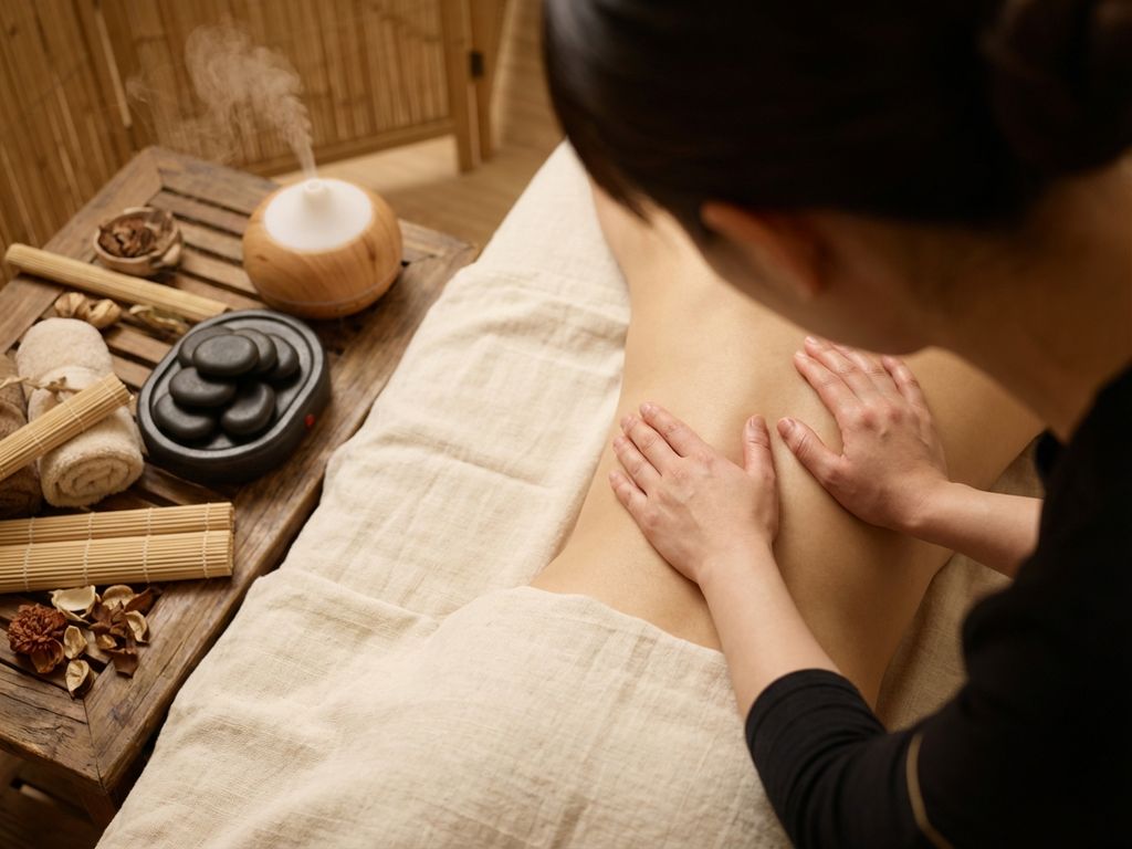 tuina-massage-therapie-wellness-behandeling.jpg Therapeutische Tuina massage op rug met traditionele Chinese technieken, warme verlichting en bamboe elementen